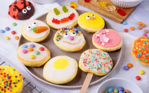 Bunte Kekse mit Zuckerguss, inspiriert von einem amerikanischen Rezept: Marienkäfer, Küken, Karotten und Gesichter.