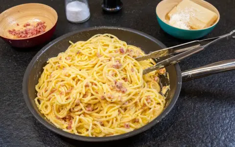 Spaghetti Carbonara, ein Klassiker der italienischen Küche, mit Speck und cremiger Eiersauce. Hier siehst du, was ist Carbonara: Nudeln, Speck und Käse.