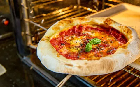 Eine köstliche Pizza mit geschmolzenem Käse und frischem Basilikum wird im Backofen gebacken.