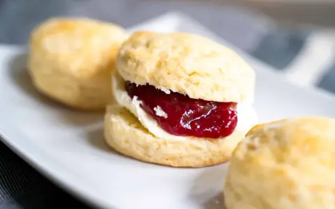 Frisch gebackene Scones mit Clotted Cream und Erdbeermarmelade. Ein perfektes Scones Rezept für den Nachmittagstee.
