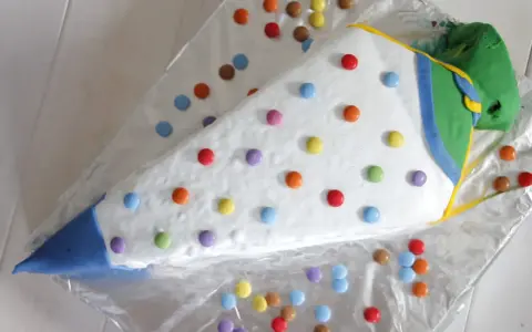 Eine bunte, schnelle Torte zur Einschulung in Form eines Zuckertüte, dekoriert mit vielen Smarties.