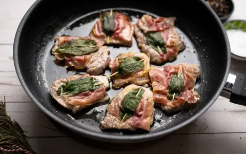 Saltimbocca alla romana in einer Pfanne, mit Salbei und Parmaschinken umwickelt.