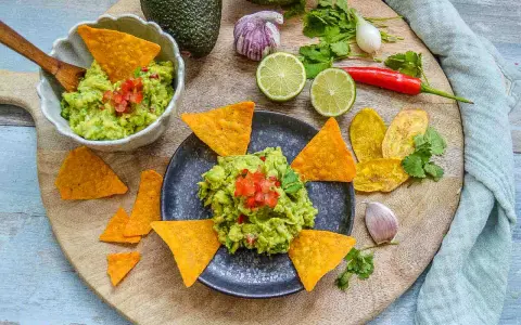 Frisches Guacamole-Rezept mit Avocados, Limetten, Chili und Koriander, serviert mit Tortilla-Chips.