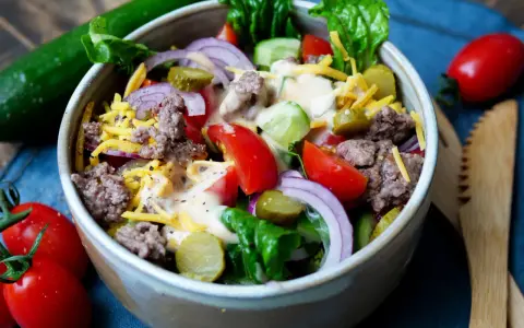Ein bunter Big Mac Salat mit Hackfleisch, Käse, Gurken, Tomaten und Zwiebeln, übergossen mit einer cremigen Sauce.