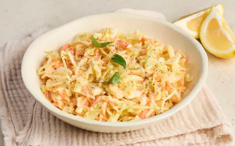Cremiger Krautsalat, perfekt für jedes coleslaw rezept. Mit frischer Petersilie und Zitronenspalten garniert.
