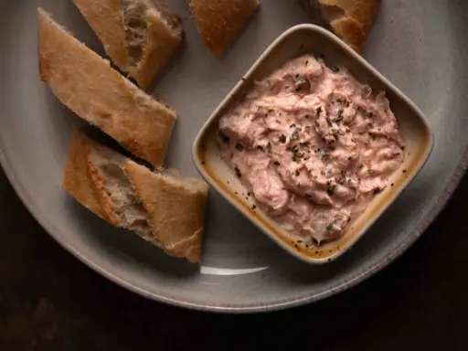 Cremige Thunfischcreme, italienisch gewürzt, mit knusprigem Baguette auf einem Teller. Ein Genuss für jeden Gaumen.