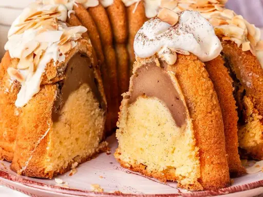 Ein saftiger Gugelhupf mit Birnenfüllung, dekoriert mit weißer Schokolade und Mandeln. Ein Klassiker unter den beliebte Kuchen rezepte.