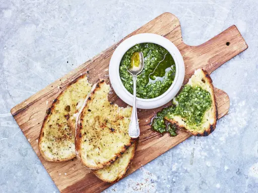 Geröstetes Brot mit frischem Chimichurri-Rezept. Ein Löffel in der Schüssel mit der grünen Sauce.