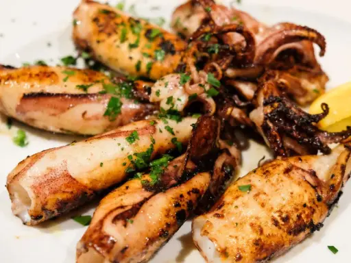 Gegrillte Tintenfischtuben mit Kräutern und Zitrone. Perfekt für ein schnelles Abendessen, aber wie lange im Ofen?