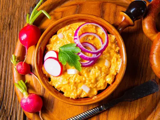 Leckeres Obazda Rezept mit Radieschen und Zwiebelringen garniert, bereit zum Genießen.