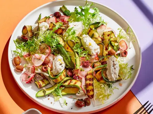 Ein köstlicher Zucchini Salat italienisch mit gegrillten Zucchinischeiben, cremigem Käse, Radieschen und Oliven.