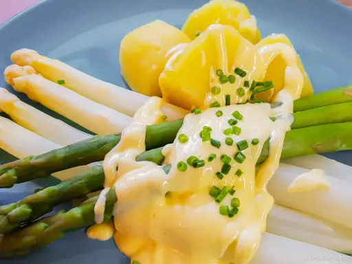 Spargel mit Kartoffeln und cremiger sauce hollandaise, garniert mit Schnittlauch.