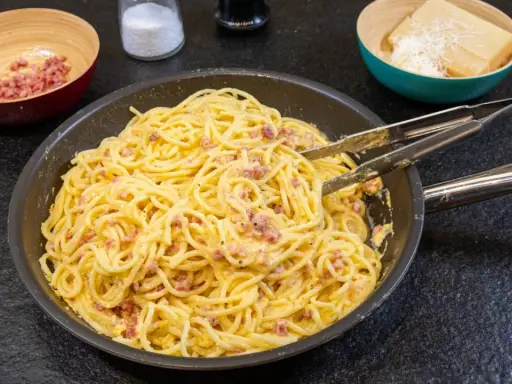 Spaghetti Carbonara, ein Klassiker der italienischen Küche, mit Speck und cremiger Eiersauce. Hier siehst du, was ist Carbonara: Nudeln, Speck und Käse.