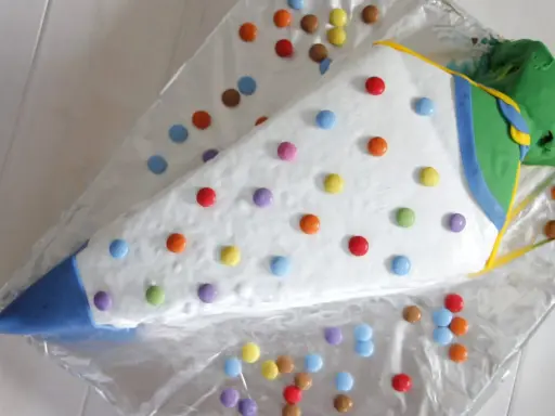 Eine bunte, schnelle Torte zur Einschulung in Form eines Zuckertüte, dekoriert mit vielen Smarties.