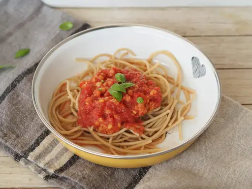 Herzhafte Linsen Bolognese auf Vollkornspaghetti, garniert mit frischem Basilikum. Ein Gericht, das Liebe und Geschmack vereint.