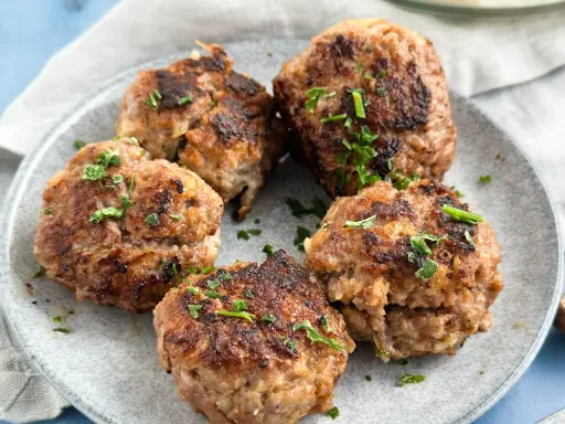 Frikadellen, frisch gebraten und mit Petersilie garniert, bereit für ein leckeres Frikadellen Rezept.