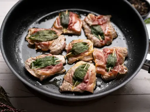 Saltimbocca alla romana in einer Pfanne, mit Salbei und Parmaschinken umwickelt.