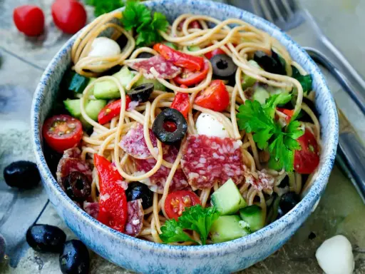 Ein bunter Spaghetti Salat mit Salami, Tomaten, Oliven und Mozzarella. Perfekt für einen spaghetti salat einfach und schnell.