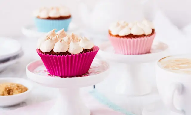 Rhabarber Muffins mit Baiser: Süße Leckereien in bunten Förmchen, bereit für den Genuss mit einer Tasse Kaffee.