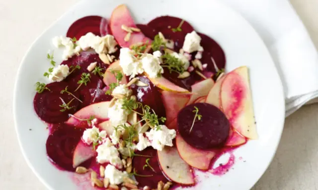 Ein bunter Rote Bete Salat mit Apfelscheiben, zerbröckeltem Käse, Sonnenblumenkernen und Kresse.