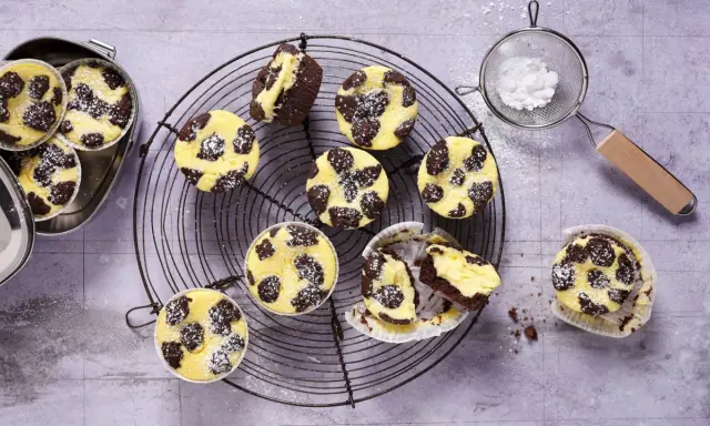 Zupfkuchen Muffins mit Puderzucker bestäubt, auf einem Gitter und in einer Dose.