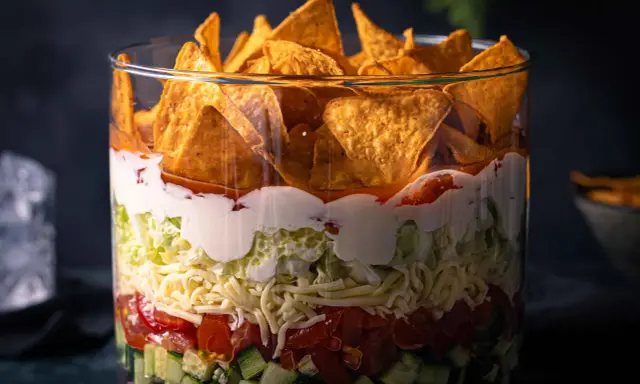 Schichtsalat im Glas: knackiger Salat, Tomaten, Käse, saure Sahne und Tortilla-Chips. Ein leckerer nacho salat.
