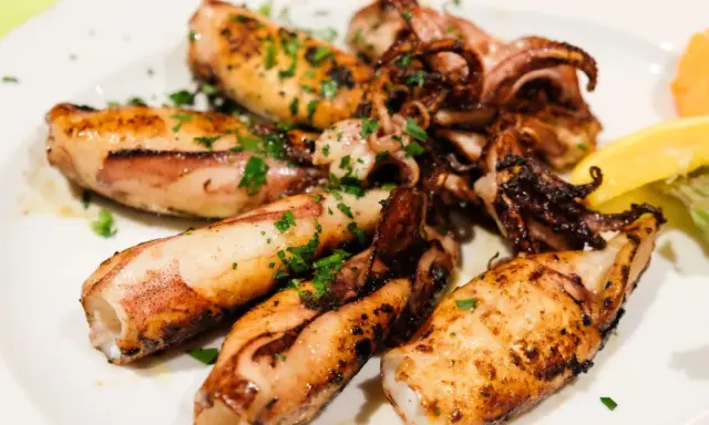 Gegrillte Tintenfischtuben mit Kräutern und Zitrone. Perfekt für ein schnelles Abendessen, aber wie lange im Ofen?