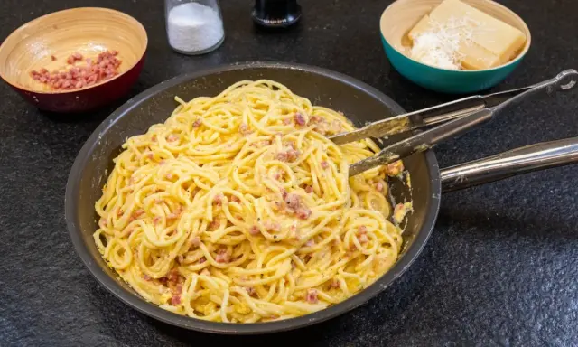 Spaghetti Carbonara, ein Klassiker der italienischen Küche, mit Speck und cremiger Eiersauce. Hier siehst du, was ist Carbonara: Nudeln, Speck und Käse.