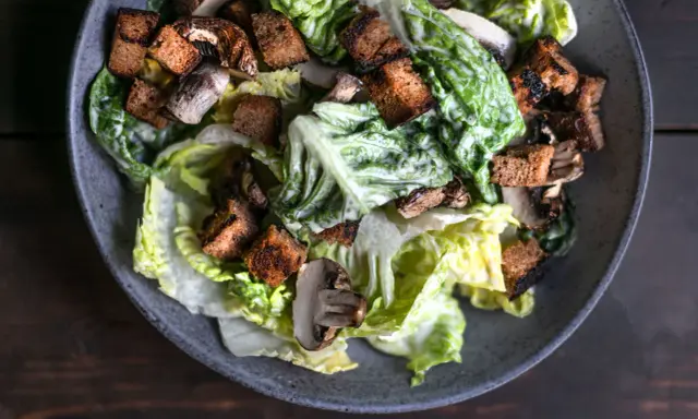 Herzhafter Caesar Salad mit knackigem Römersalat, gerösteten Croutons und Pilzen, übergossen mit cremiger Sauce.
