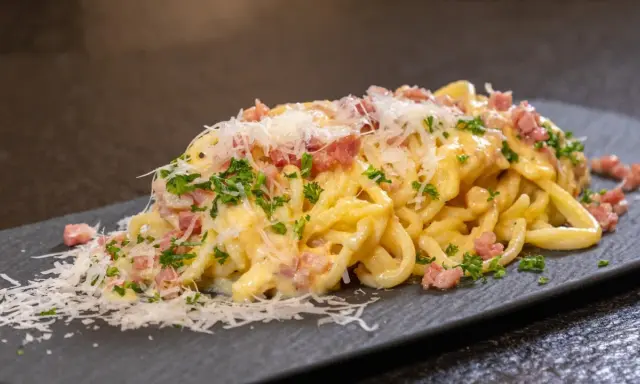 Ein köstliches Spaghetti Carbonara Rezept einfach zubereitet, mit cremiger Sauce, Speckwürfeln und frisch geriebenem Parmesan.