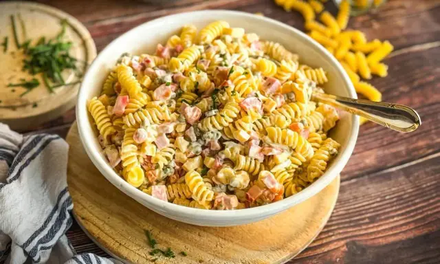 Schüssel mit cremigem Nudelsalat, gefüllt mit Schinken, Erbsen und Kräutern. Der beste Nudelsalat für jede Gelegenheit!
