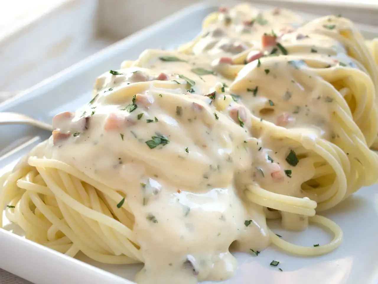 Spaghetti Carbonara mit cremiger Sauce, Speck und Petersilie. Ob mit nur Eigelb oder ganzem Ei, diese Carbonara ist ein Genuss.