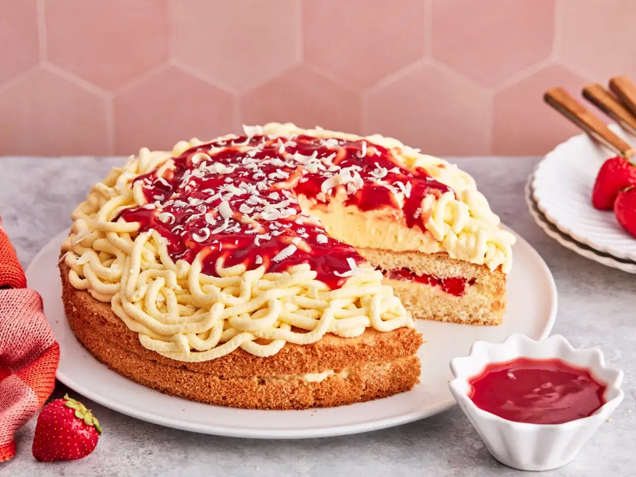 Eine k&ouml;stliche Spaghettieis Torte mit Erdbeerso&szlig;e und Kokosraspeln, die wie Spaghetti aussehen.