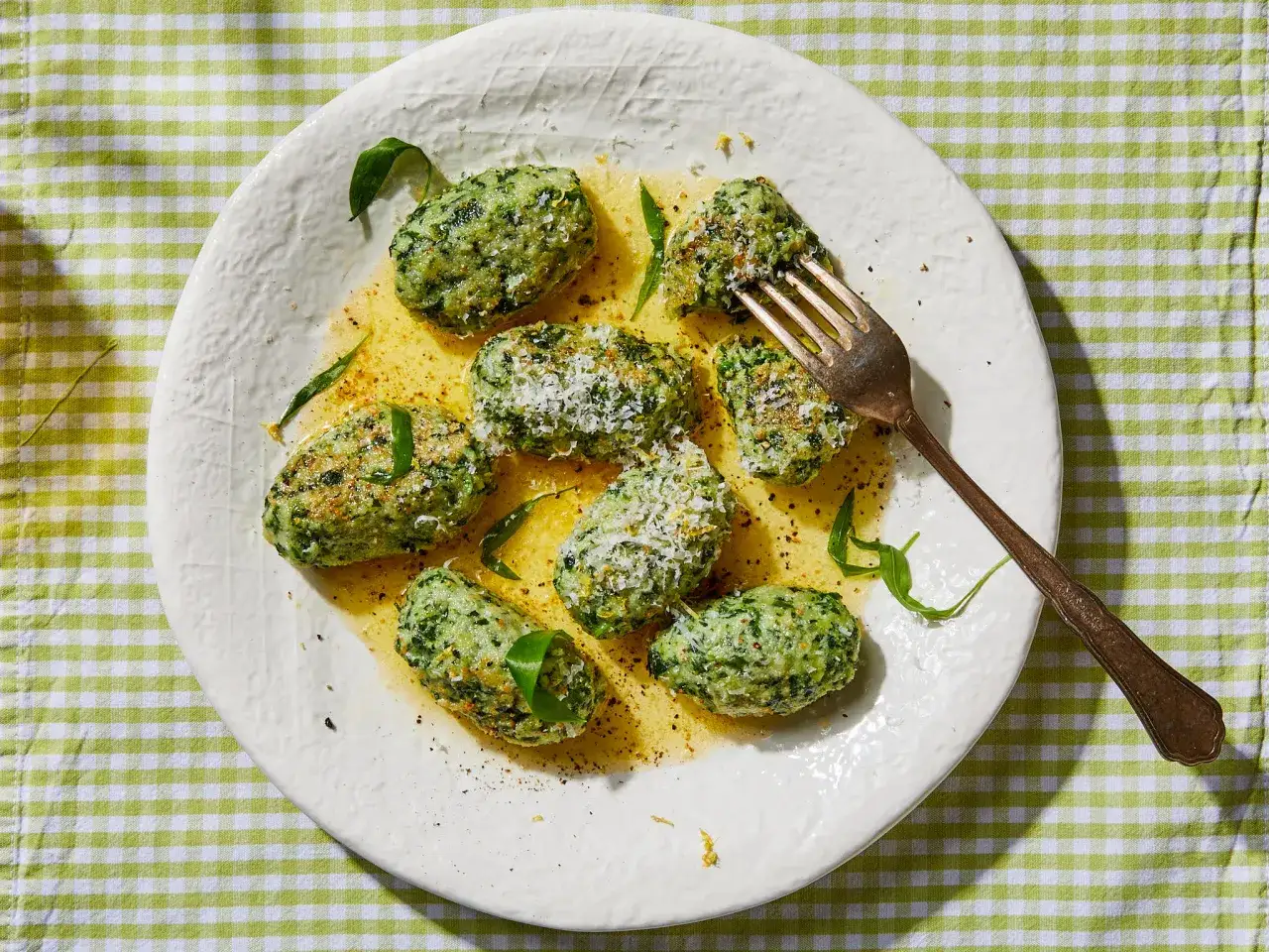 Malfatti Rezept: Gr&uuml;ne Kl&ouml;&szlig;chen mit Parmesan und Butter auf einem Teller, bereit zum Genie&szlig;en.