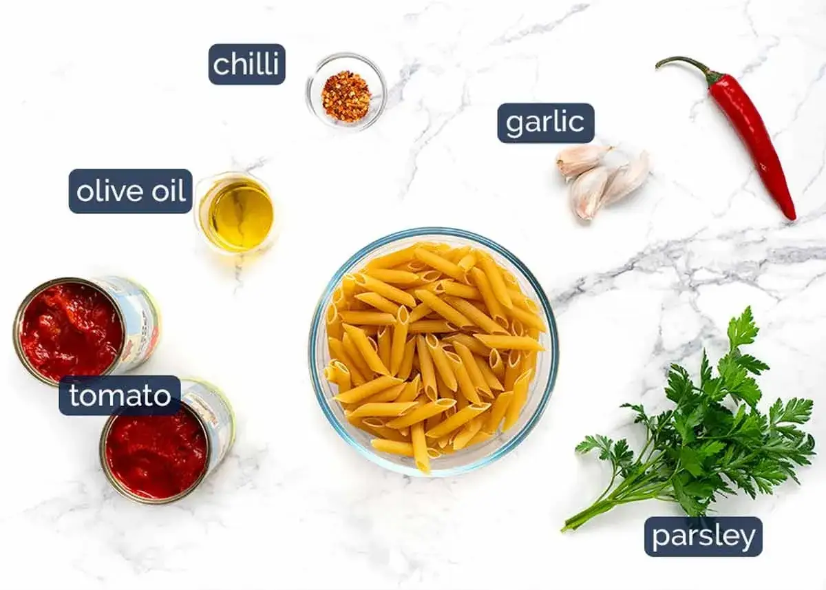 Zutaten f&uuml;r Penne all'Arrabbiata: Penne-Nudeln, Tomaten, Oliven&ouml;l, Knoblauch, Chili und Petersilie.