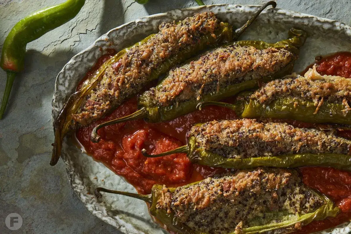 Gef&uuml;llte Peperoni, die zeigen, was ist Peperoncino: scharfe, gr&uuml;ne Chilischoten, gef&uuml;llt und &uuml;berbacken, serviert in Tomatensauce.