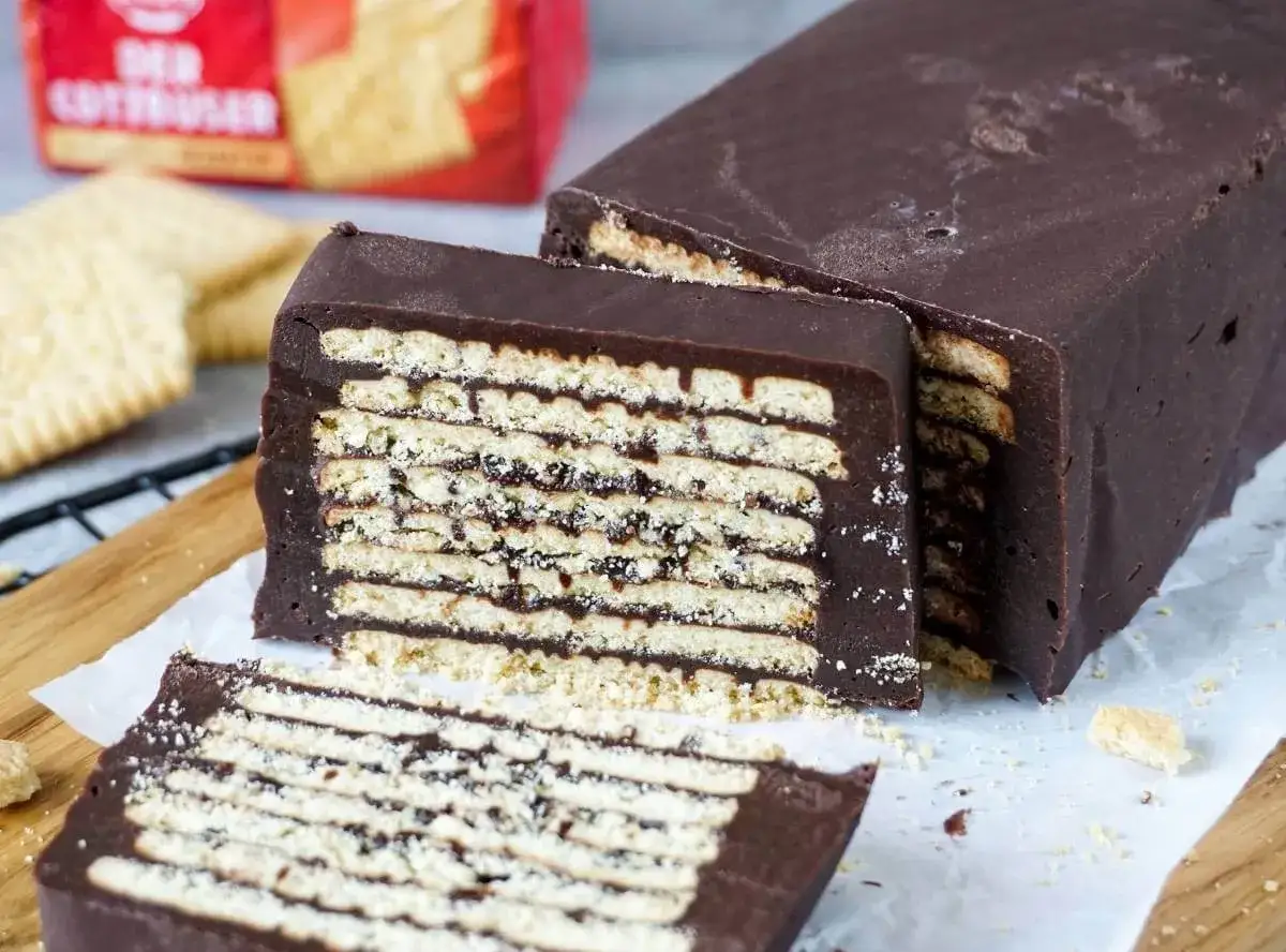 Schokoladenkuchen mit Schichten von Keksen und Schokoladencreme. Ein Stück ist abgeschnitten, was die kalte Schnauze-Schichtung zeigt.