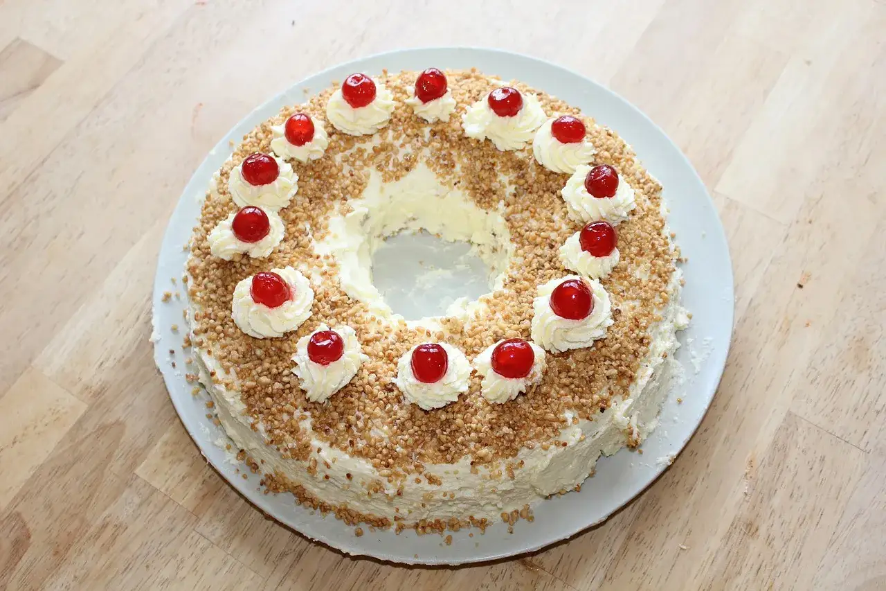 Ein Kranzkuchen mit Buttercreme, gehackten N&uuml;ssen und Kirschen. Ein Klassiker unter den beliebte Kuchen Rezepten, der immer gut ankommt.