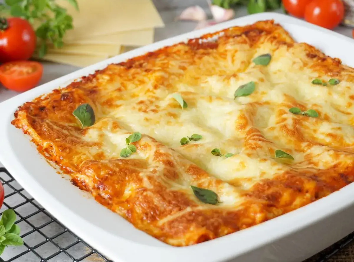 Frisch gebackene Lasagne im Auflaufform, goldbraun &uuml;berbacken, mit frischen Kr&auml;utern garniert. Ein authentisches lasagne rezept original.