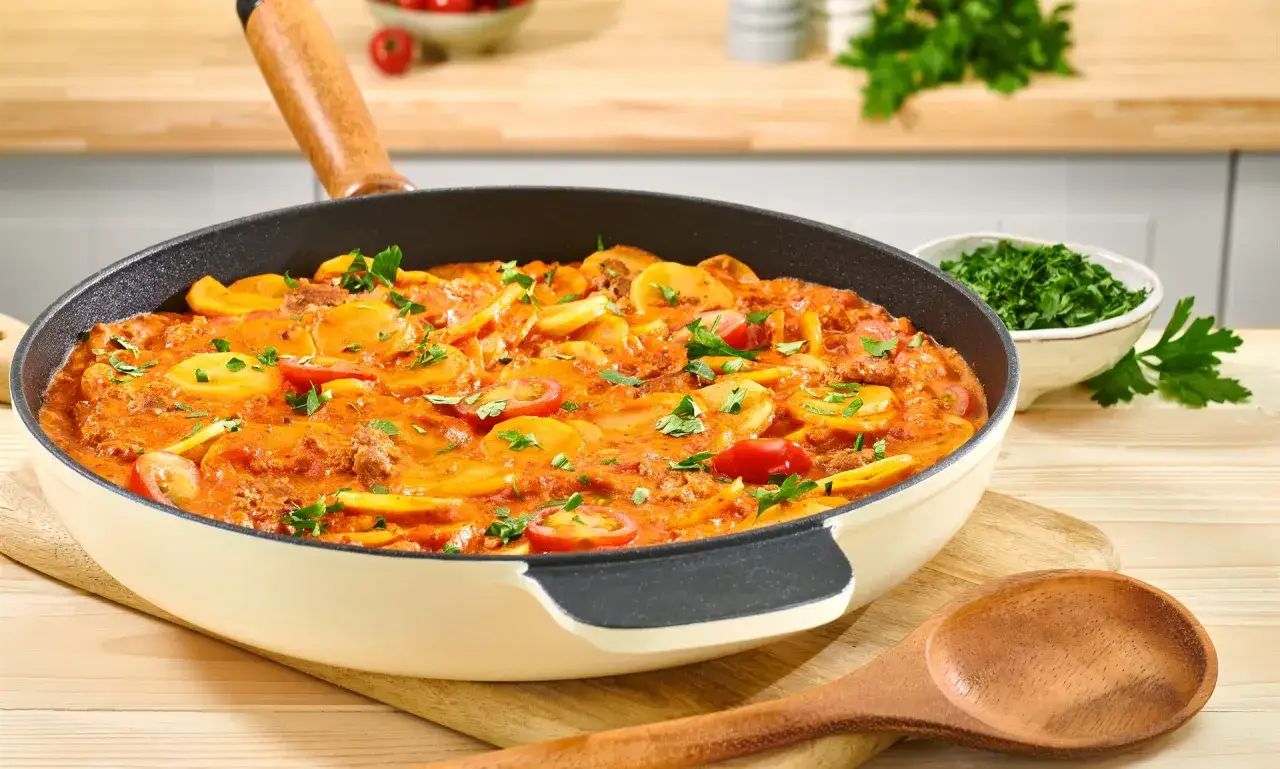 Herzhaftes Gericht mit Hackfleisch, Kartoffelscheiben und Tomaten in einer cremigen Sauce, garniert mit Petersilie. Ein leckeres Beispiel f&uuml;r Hackfleisch Gerichte.