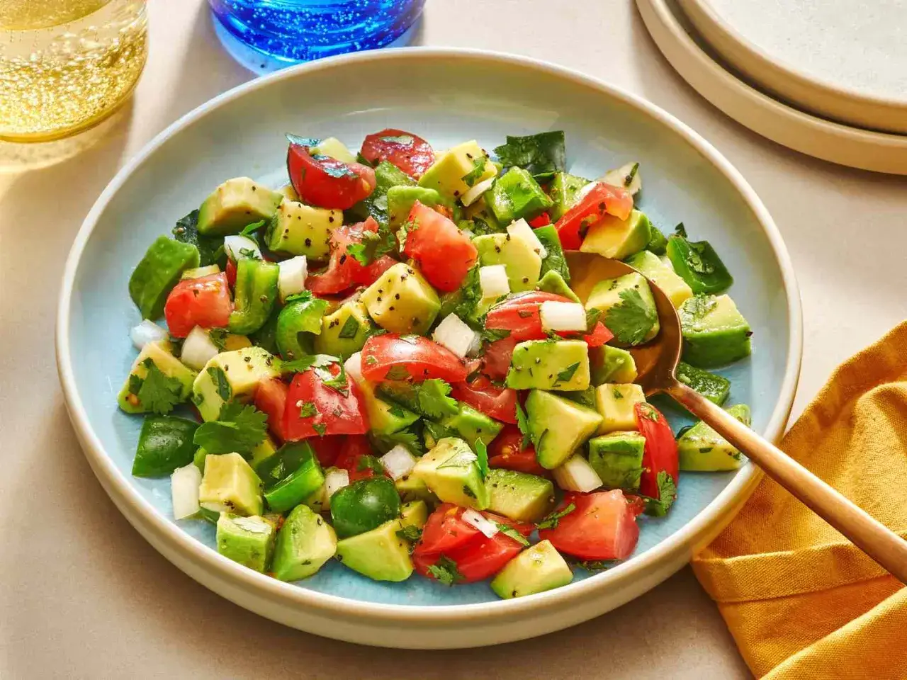 Frischer Avocado Salat mit Tomaten, Gurken und Koriander, perfekt f&uuml;r einen leichten Genuss.