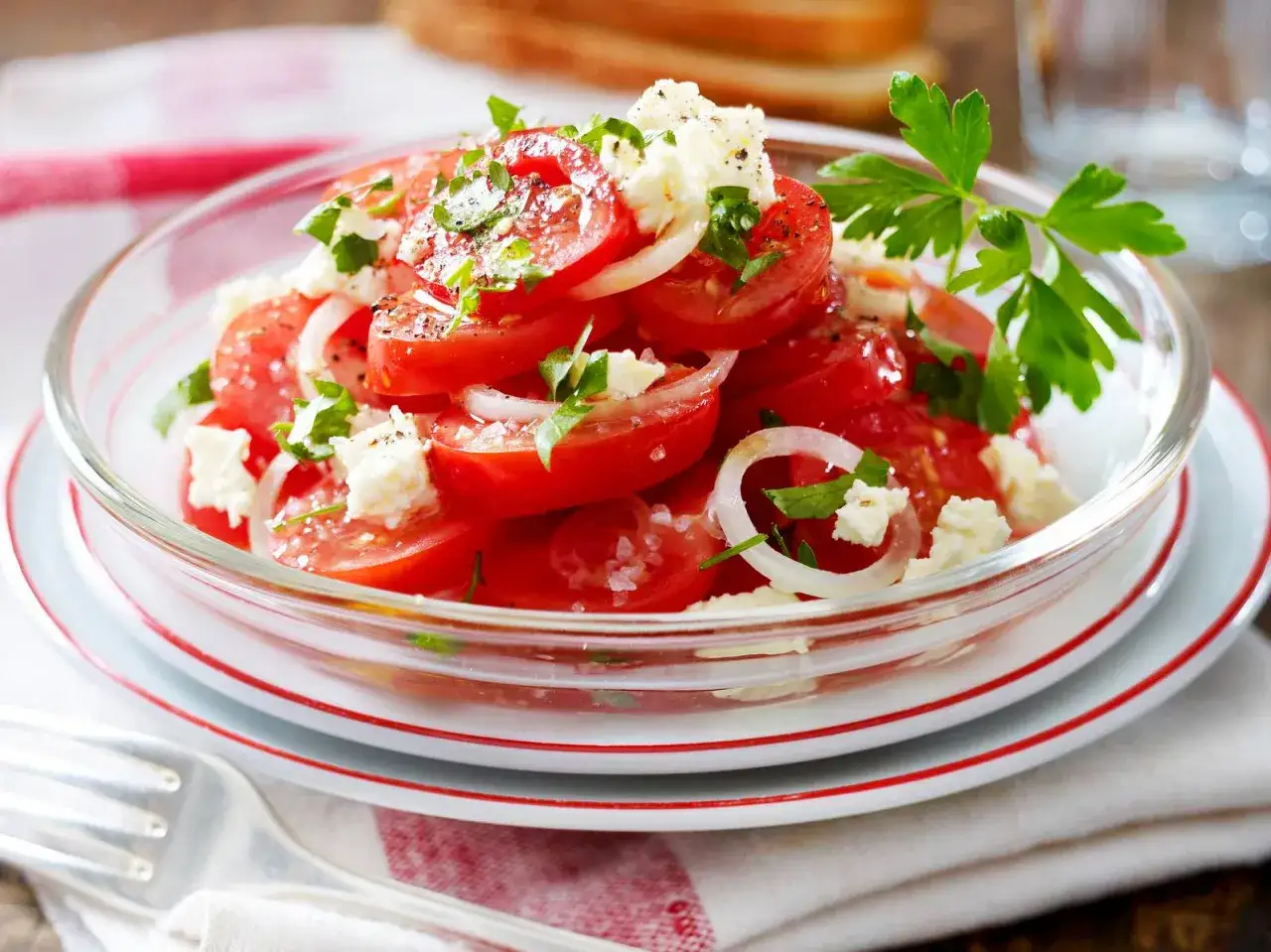 Frischer tomatensalat mit feta, Zwiebeln und Petersilie, garniert mit Pfeffer und Salz. Ein leichter Genuss!