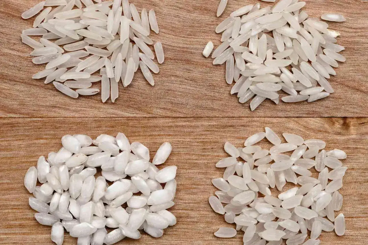 Vier Haufen Reis auf Holz: Oben links und rechts Langkornreis, unten links und rechts Rundkornreis, ideal f&uuml;r cremigen Risotto Reis.