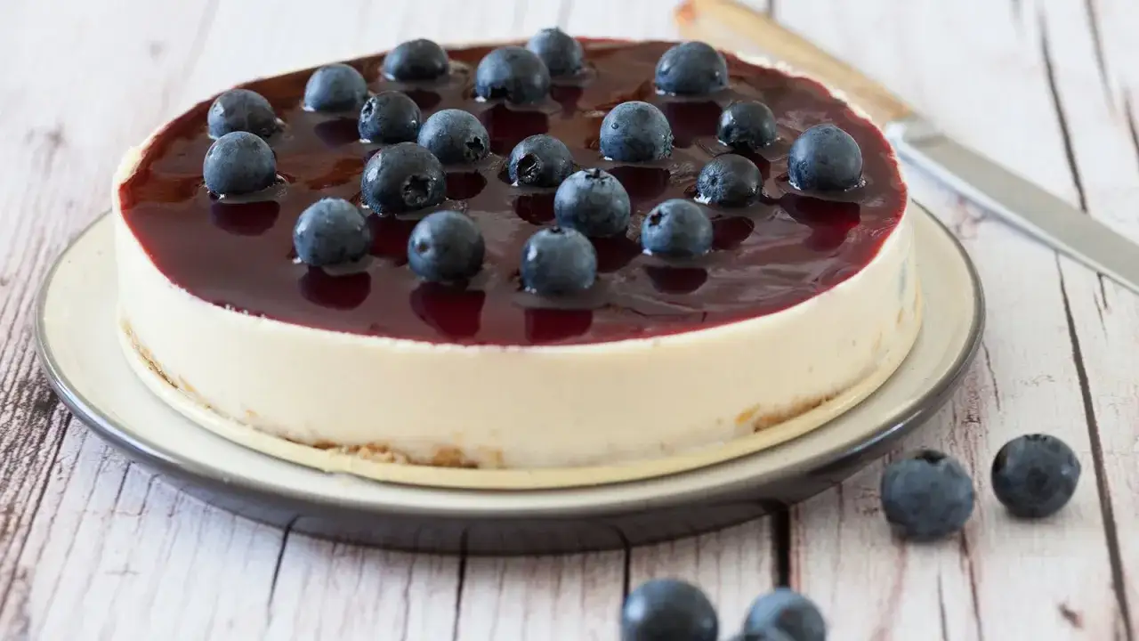 Eine k&ouml;stliche Heidelbeertorte ohne Backen, gekr&ouml;nt mit frischen Beeren und gl&auml;nzender Blaubeersauce. Perfekt f&uuml;r hei&szlig;e Tage!