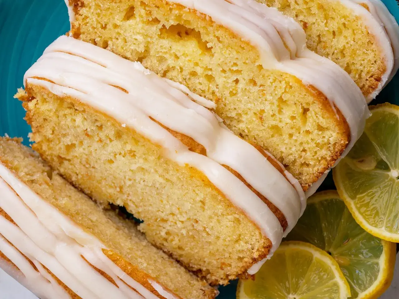 Saftiger Joghurt Zitronen Kuchen mit Zuckerguss und frischen Zitronenscheiben.