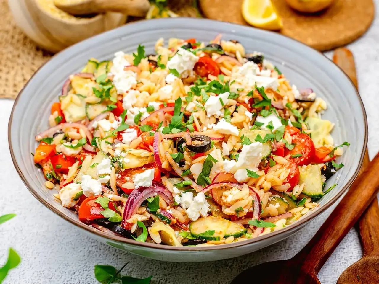Bunter Kritharaki Salat mit Tomaten, Gurken, roten Zwiebeln, Oliven und Feta. Ein erfrischender Genuss!