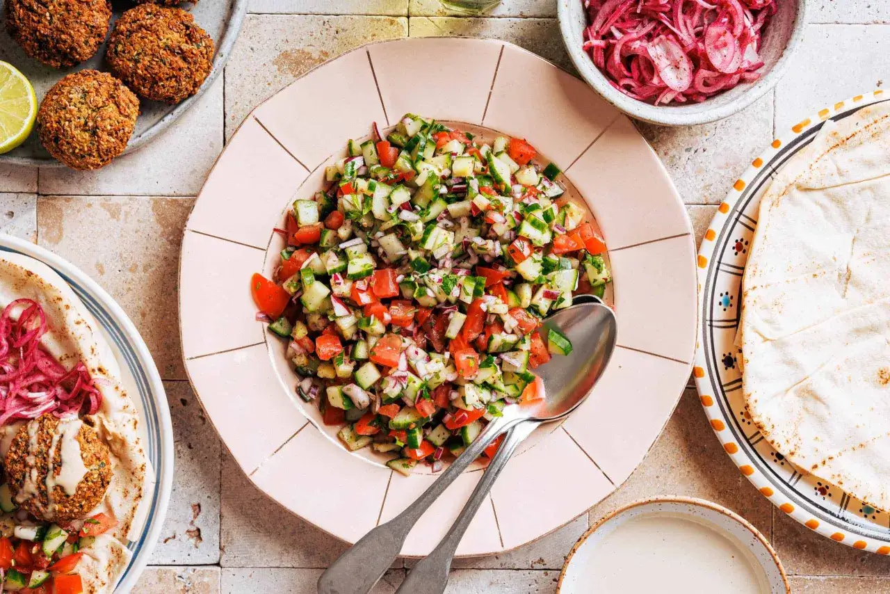 Frischer Sommersalat mit Tomaten, Gurken und Zwiebeln, perfekt als Beilage zu Falafel. Ein leichtes Sommersalat Rezept.
