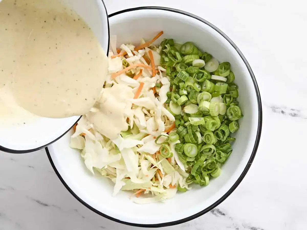 Cremiges Dressing wird &uuml;ber fein geschnittenen Kohl, Karotten und Fr&uuml;hlingszwiebeln gegossen. Perfekt f&uuml;r ein einfaches Coleslaw Rezept.