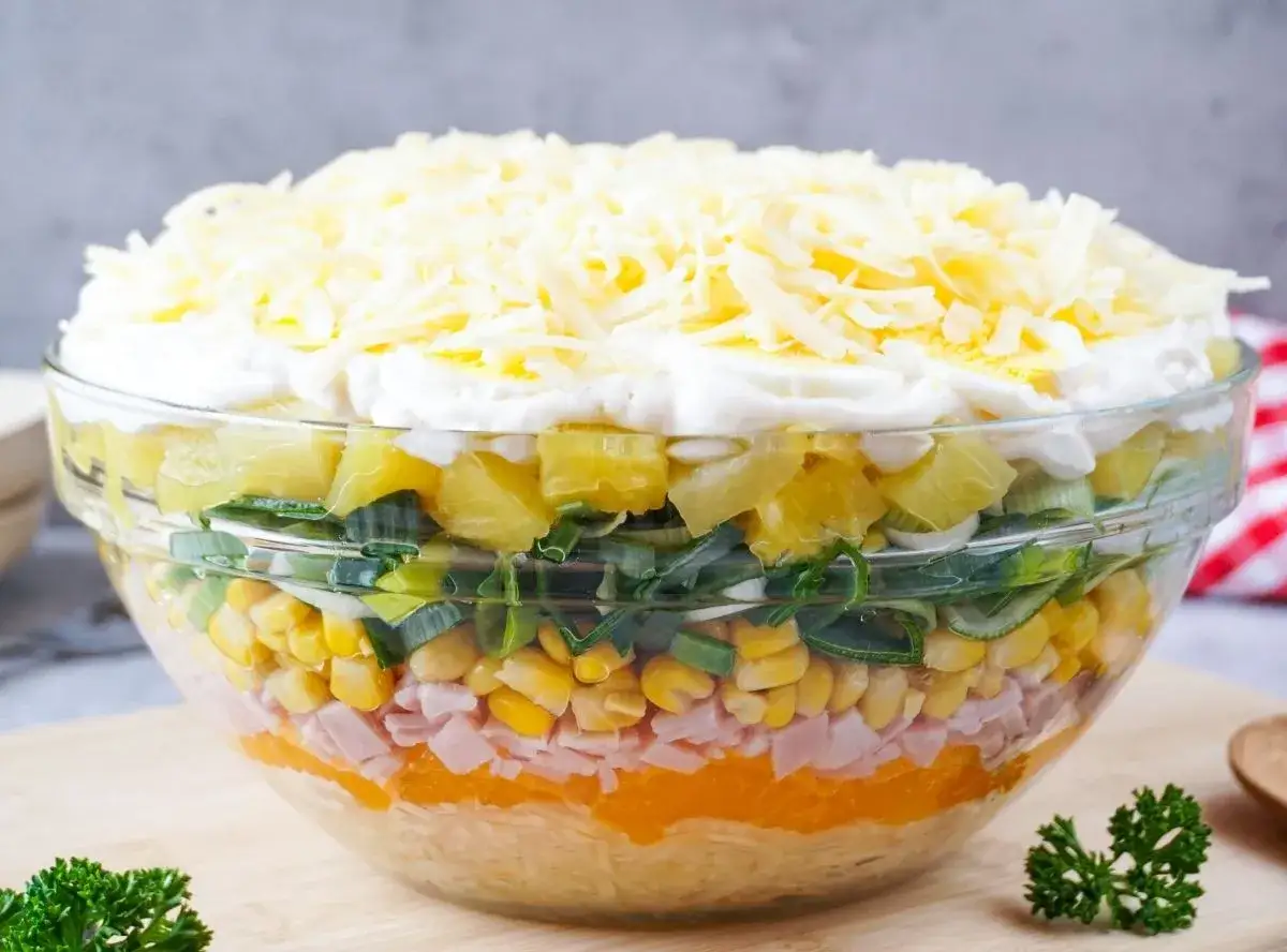 Schichtsalat-Rezept: Bunter Salat in Schichten mit Ananas, Mais, Schinken, Lauch und Käse.