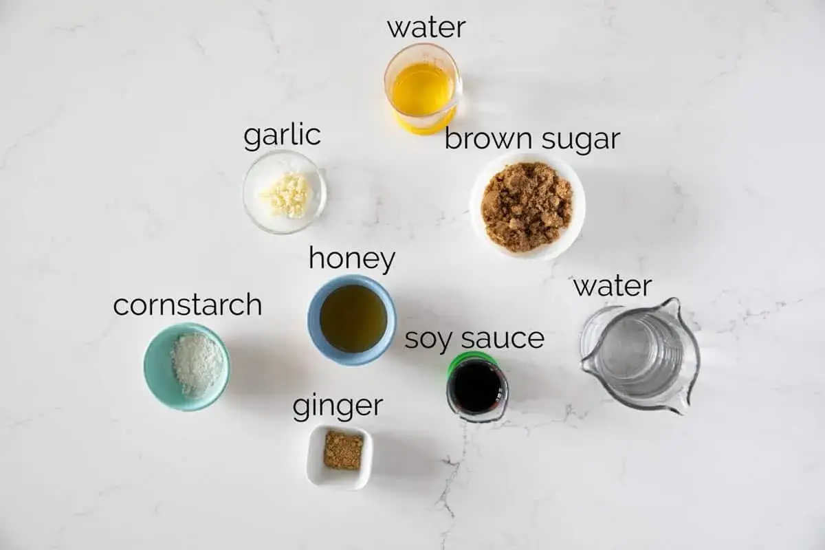 Zutaten f&uuml;r ein einfaches Teriyaki Sauce Rezept: Sojasauce, Honig, brauner Zucker, Knoblauch, Ingwer, Maisst&auml;rke und Wasser.